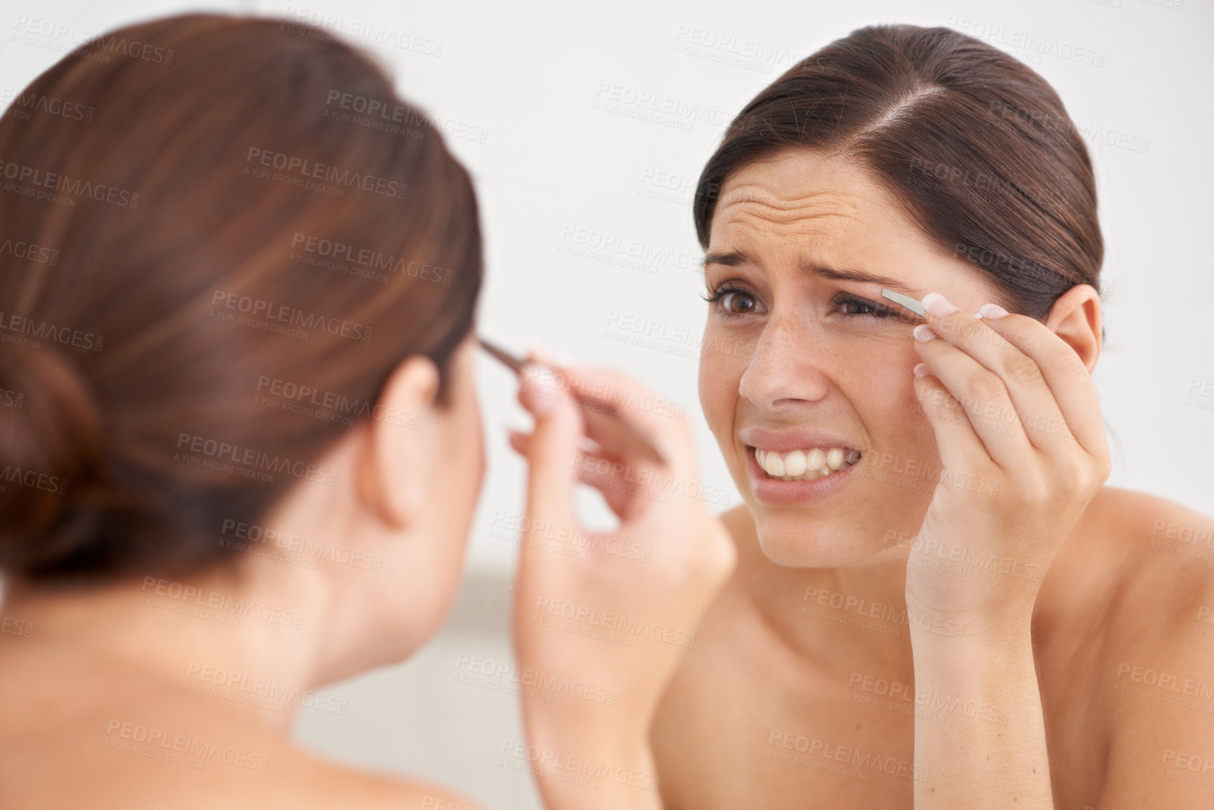 Buy stock photo Eyebrow, plucking and woman with pain for beauty, self care and mirror in bathroom. Makeup, routine and girl with hair removal, tools and facial grooming or treatment for skincare and cosmetics