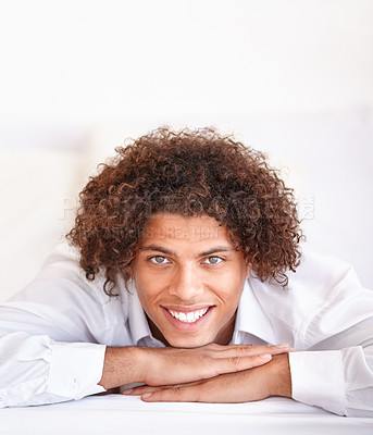 Buy stock photo Man, portrait and happy relaxing in bed on weekend, comfortable and lazy or resting in apartment. Male person, face and smiling in bedroom and calm or peace on holiday or vacation in Amsterdam