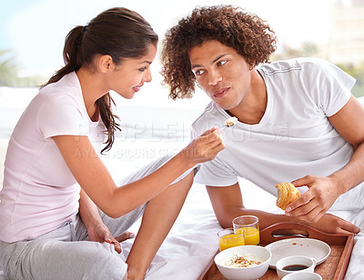 Buy stock photo Couple, feeding and breakfast in bed for bonding, healthy meal and celebrating anniversary at home. People, marriage milestone and love or loyalty in relationship, romance and food for nutrition