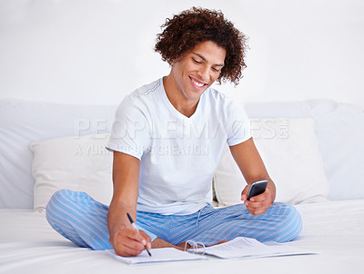 Buy stock photo Man, writer and planning in journal, writing ideas and inspiration or research in bed at home. Male person, author and notes in book for project, brainstorming and smartphone for info in bedroom