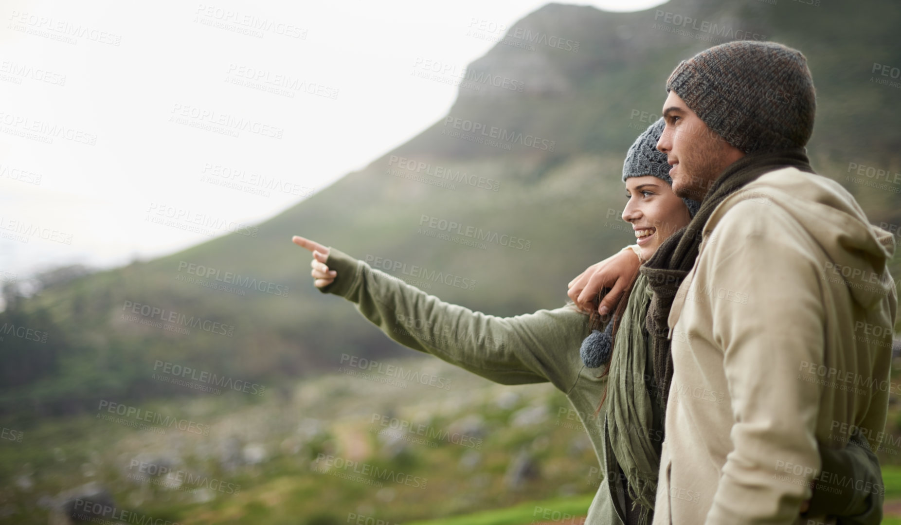 Buy stock photo A young couple admiring the view while out hiking during winter