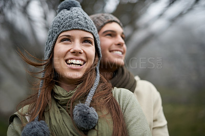 Buy stock photo A happy young couple enjoying the sights while hiking through the mountain