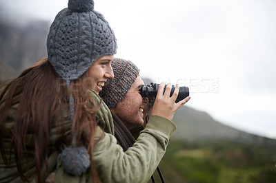 Buy stock photo Couple, travel and binoculars on mountains for journey, adventure and hiking or explore together in winter. Happy man and woman trekking with outdoor search, vision or birdwatching lens in nature