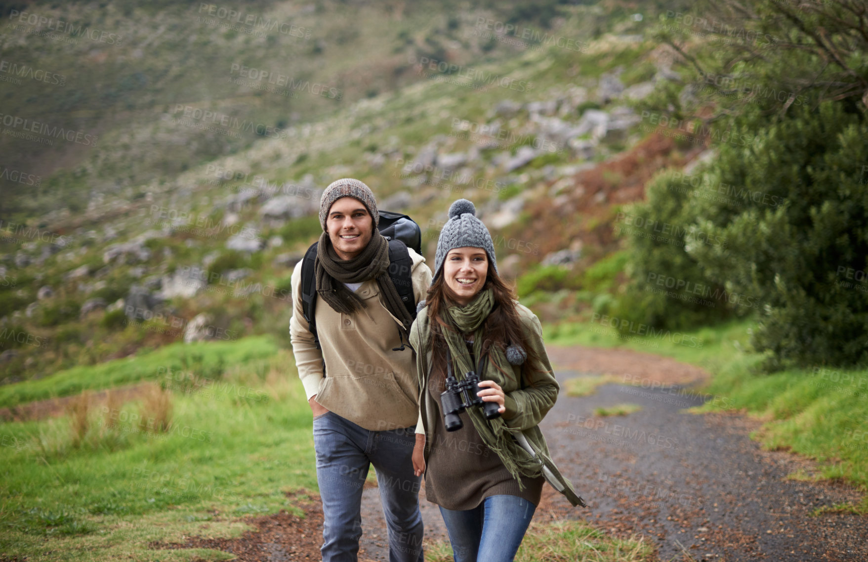 Buy stock photo Forest, hiking and happy with couple, binoculars and walking with backpack, mountain and bonding together. Outdoor journey, adventure and trekking in path, field and exercise for fitness and travel
