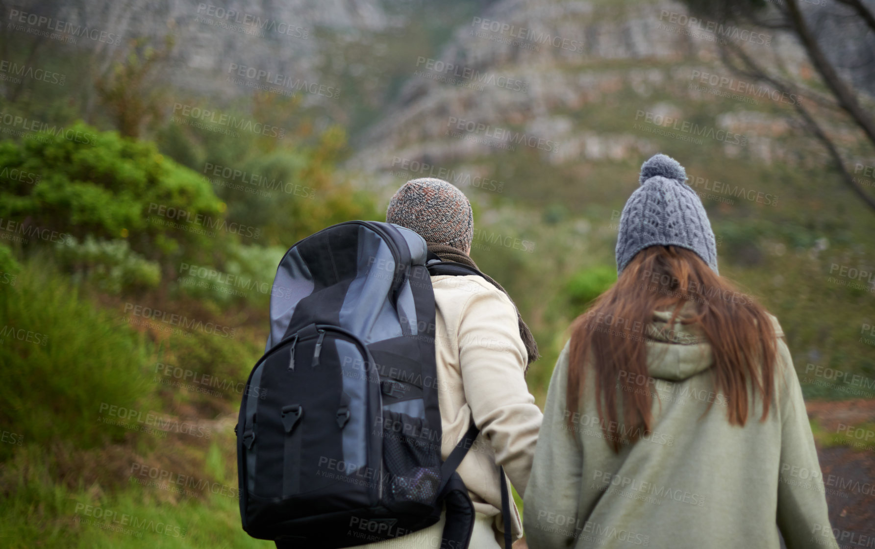 Buy stock photo Outdoor, hiking and couple in mountain, holding hands and walking with backpack, nature and bonding together. Forest, adventure and trekking in path, field and exercise for fitness and travel
