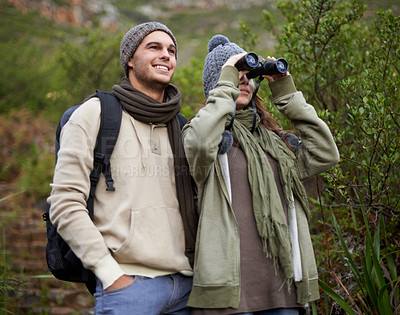 Buy stock photo Couple, travel and binoculars in nature for hiking, adventure and journey or explore together in winter. Happy man and woman trekking with outdoor search, vision or birdwatching in forest or woods
