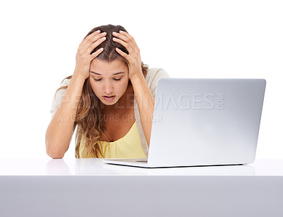 Buy stock photo Studio shot of a young woman looking stressed while sitting in front of her laptop