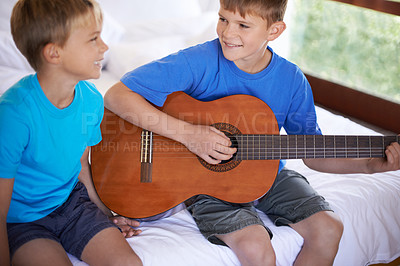 Buy stock photo Children, music and siblings on a bed with guitar for playing, bonding or learning together in their home. Musical instrument, love and kids in  bedroom with acoustic sound, teaching or having fun