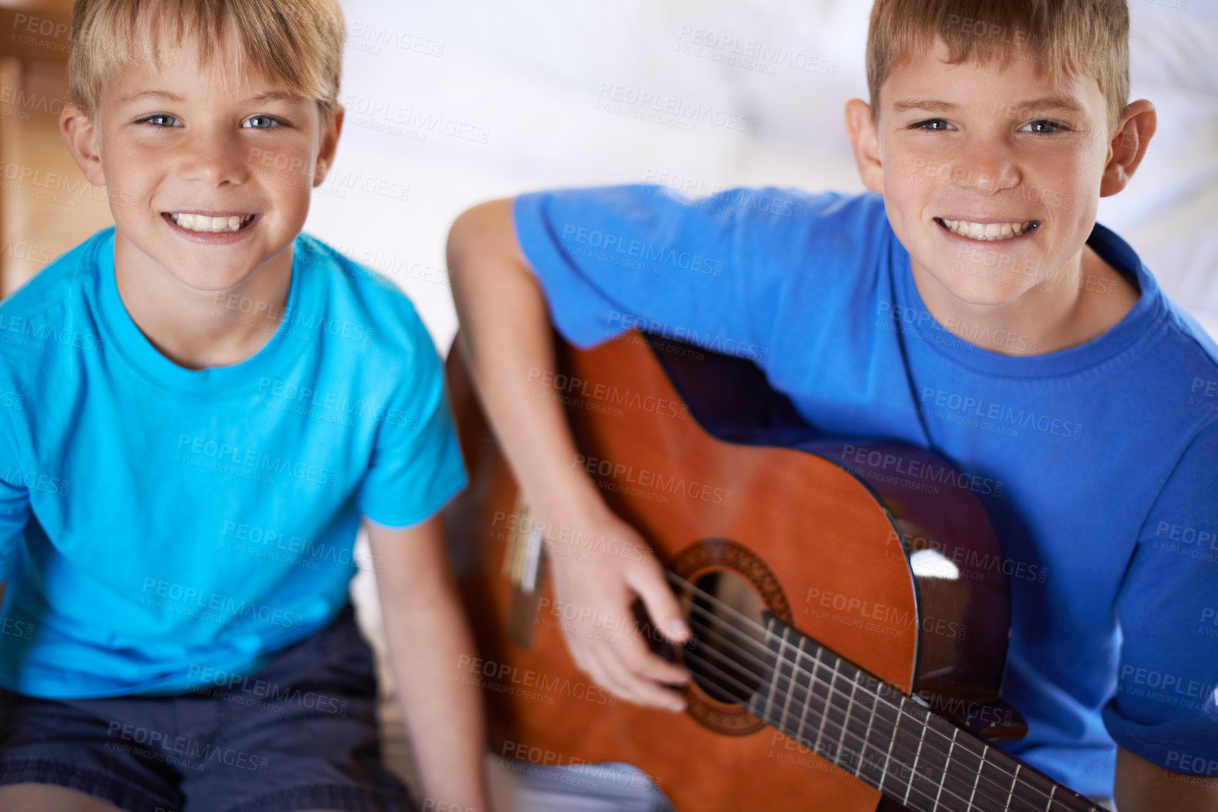 Buy stock photo Smile, portrait and children with guitar on bed for playing or practicing music together at home. Happy, bonding and young boy kids learning an acoustic string instrument in bedroom at house.
