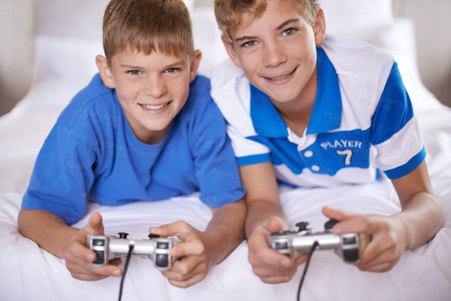 Buy stock photo Children, happy and portrait of video game in home, love and excited for online gaming in bedroom. Young brothers, smile and face for streaming sports on bed, bonding and relax together on weekend