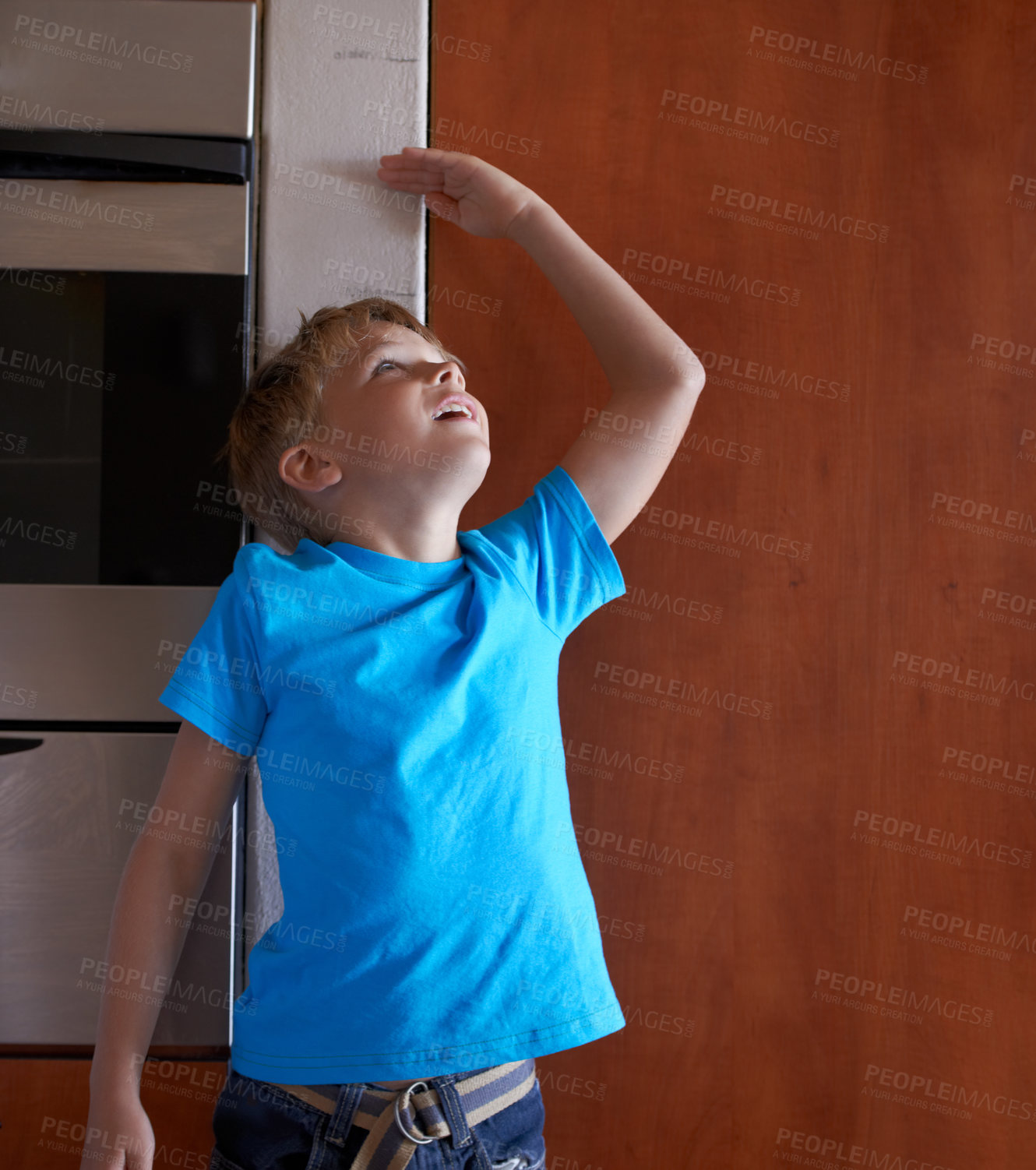 Buy stock photo A young boy measuring his height at home