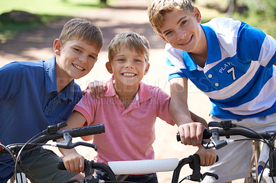 Buy stock photo Brothers, bicycle and portrait for together in park, playing and excited for fun outdoor on vacation. Young children, face and bike riding for skill development, love and bonding in summer on holiday