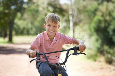 Buy stock photo Nature, smile and portrait of child on bicycle riding in outdoor field, park or forest for exercise. Happy, cycling and confident young boy kid on a bike for cardio, hobby or training in a garden.