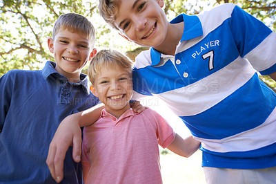 Buy stock photo Portrait of three young brothers enjoying a day outside