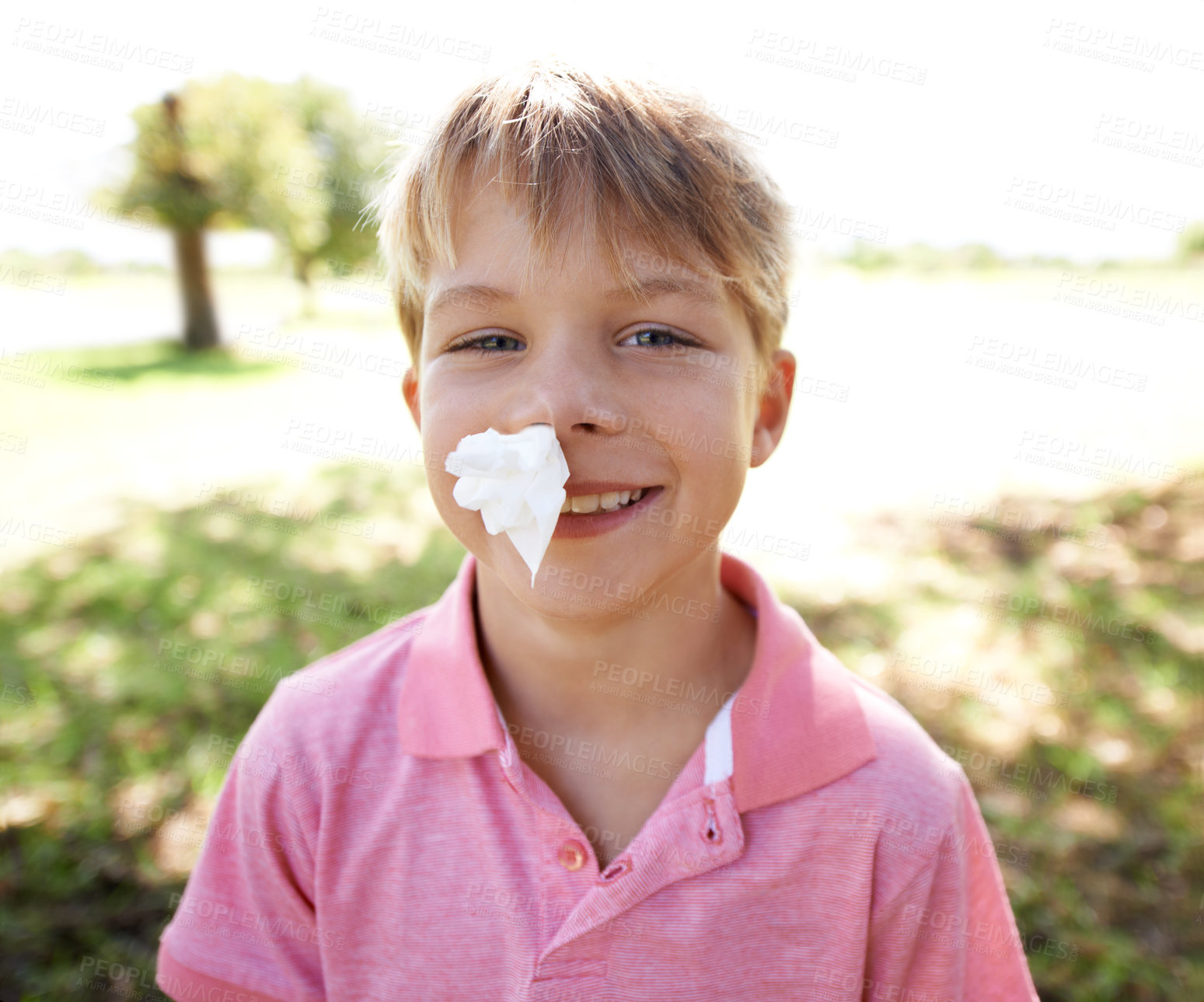 Buy stock photo Child, portrait and nose bleed or paper for outdoor adventure or accident, injury or smile. Kid, boy and happy face with tissue for blood on forest playground for physical activity, sports or nature