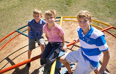 Buy stock photo Friends, brothers and playing at park in portrait, kids and smile on merry go round at playground. Happy siblings, carousel and bonding on outdoor adventure, boys and active on vacation or holiday