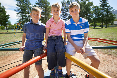 Buy stock photo Friends, brothers and smiling on playground in portrait, children and play on merry go round at park. Happy siblings, carousel and bonding on outdoor adventure, love and active on vacation or holiday