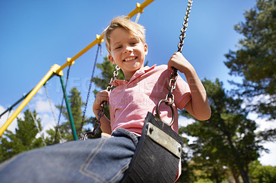Buy stock photo Child, swing and fun on playground in portrait, smile and outdoor adventure in childhood for recreation at park. Happy male person, active and energy on equipment, boy and play on vacation or holiday