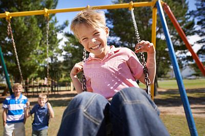 Buy stock photo Child, swing and energy on playground in portrait, smile and outdoor adventure in childhood for recreation at park. Happy male person, active and freedom on equipment, boy and playing on vacation