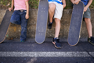 Buy stock photo Kids, friends and skateboard for outdoor relax or exercise sneakers for workout, balance or city street. People, legs and neighbourhood wall rest or fitness on road or transport, practice or urban
