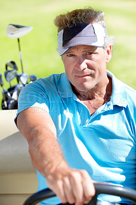 Buy stock photo A happy mature golfer driving in a golf cart