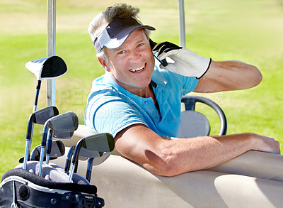 Buy stock photo A mature golfer sitting in a cart speaking on his cellphone