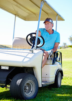 Buy stock photo A mature man driving a cart over the golf course