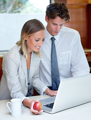 Buy stock photo Happy couple, coffee and apple by laptop in kitchen for morning, healthy breakfast or research at home. Man and woman with cup of tea and organic fruit in remote work, meal or nutrition on computer
