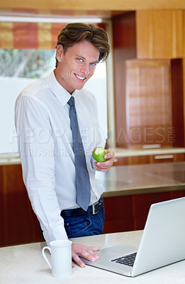 Buy stock photo Laptop, apple and portrait of business man in home for morning routine, kitchen and healthy breakfast. Professional, worker and person on computer for website, research and internet with fruit