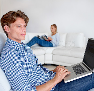 Buy stock photo Laptop, thinking and man on sofa in home for internet, online website and social networking. Happy, couple and woman reading magazine with person on computer for relaxing, research and remote work