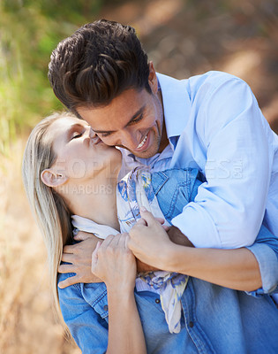 Buy stock photo Happy couple, kiss and hug in nature for affection, love or support in outdoor walk or bonding. Young woman kissing man on cheek with smile for embrace, comfort or romance in forest or woods together