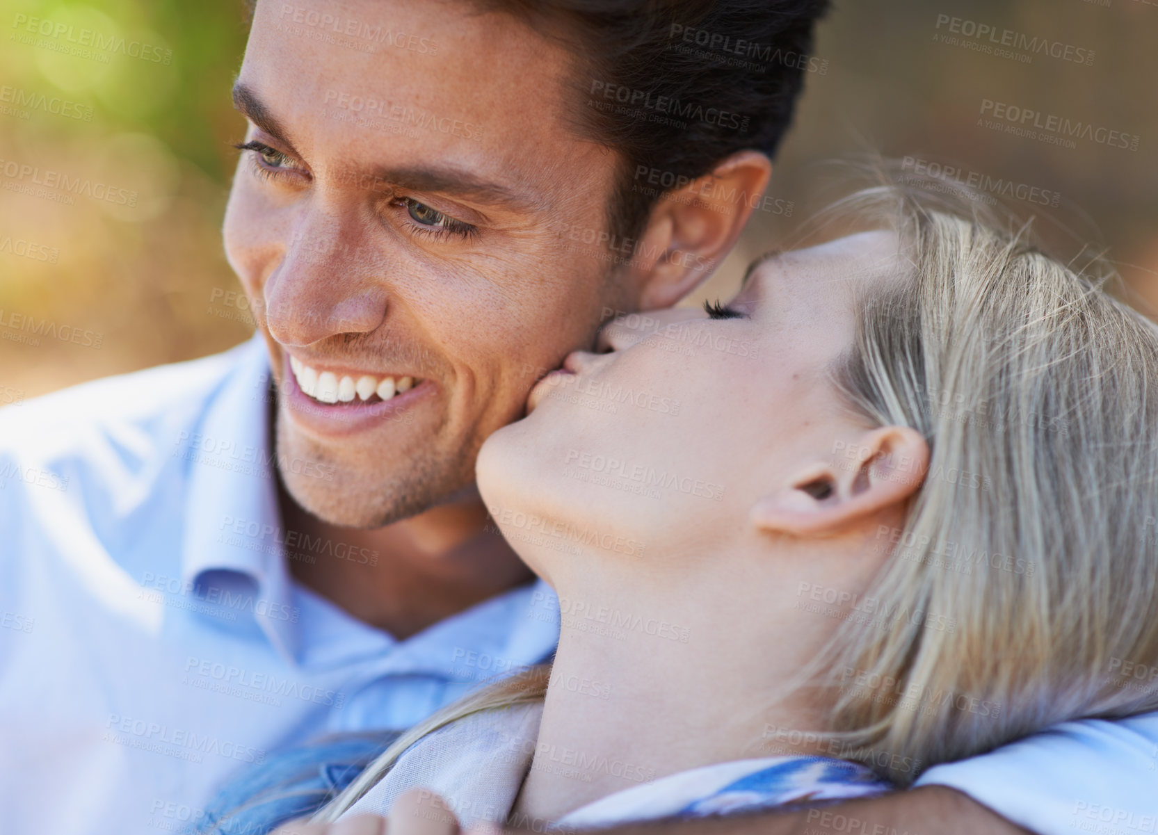 Buy stock photo Happy couple, closeup and kiss in nature for embrace, love or support in relax for outdoor bonding. Young woman kissing man on cheek with smile for affection, comfort or romance in forest together