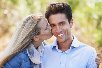 Buy stock photo Happy couple, portrait and kiss on cheek in nature for love, bonding or support in relax for outdoor affection. Face of young woman and man smile for embrace, intimacy or romance in forest together