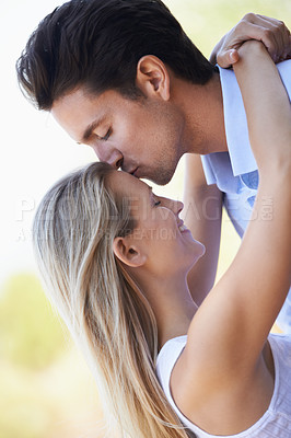 Buy stock photo Happy couple, kiss and hug in nature for romance, support or affection in outdoor bonding. Young man and woman forehead with smile for embrace, comfort or love in forest or woods together on date