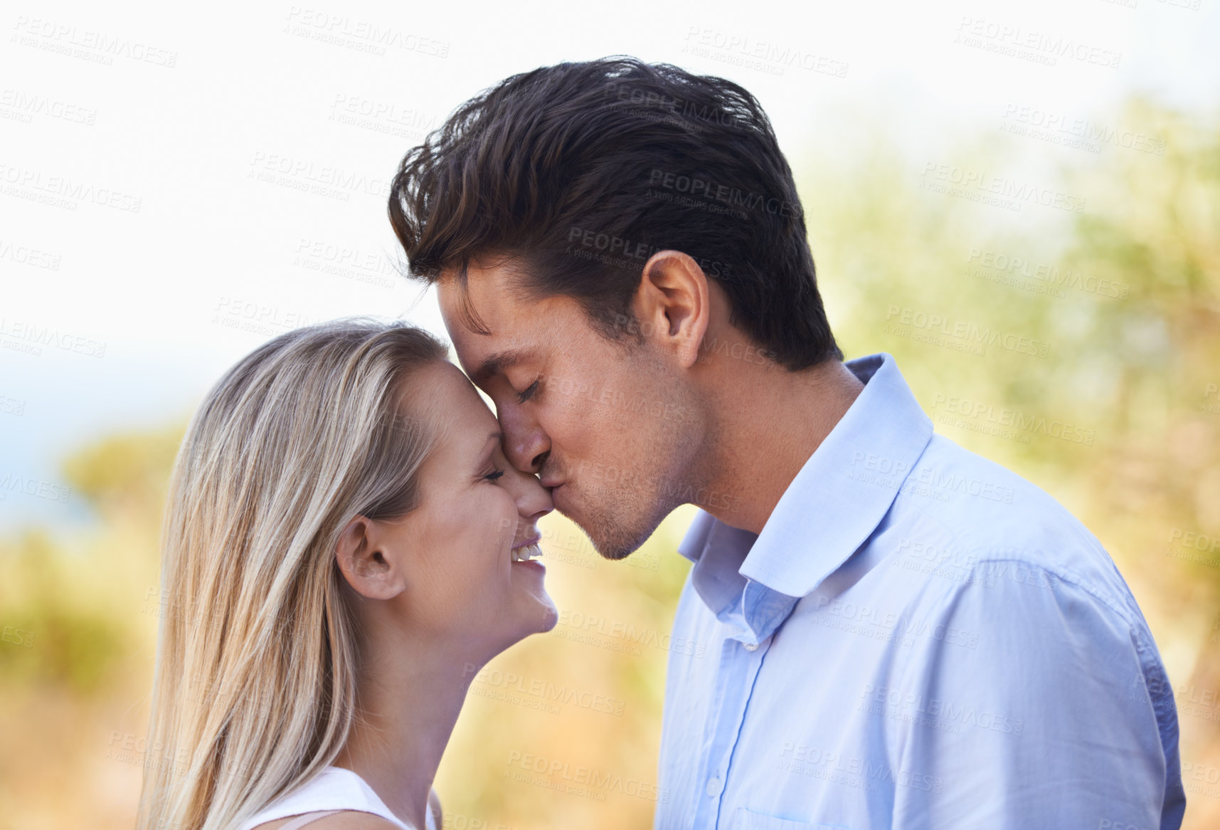 Buy stock photo Happy couple, kiss and nature for romance, support or affection in outdoor bonding or date. Young man kissing woman on nose with smile for embrace, comfort or love in forest or woods outside together