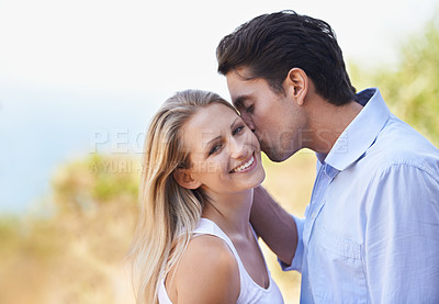 Buy stock photo Happy couple, portrait and kiss in nature for romance, support or affection in outdoor bonding or date. Man and woman with smile on cheek for embrace, comfort or love in forest or woods together