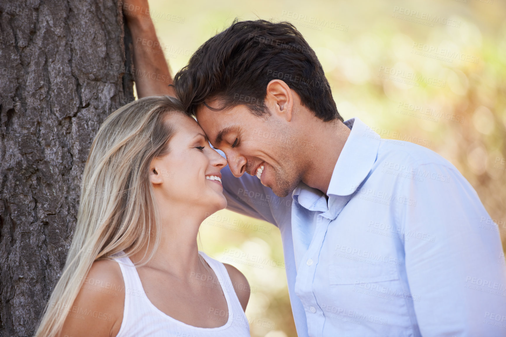 Buy stock photo Happy couple, nature and affection for love, support or embrace in outdoor comfort or bonding. Young woman and man relaxing on tree with smile for intimacy or romance in forest or woods together