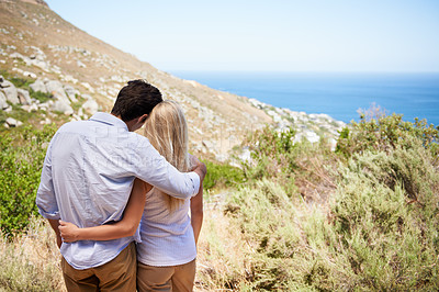 Buy stock photo Couple, hug and love on mountains for travel, journey and holiday in nature with blue sky and ocean view. Back of romantic people on eco friendly date, hiking on hill and valentines day or tourism