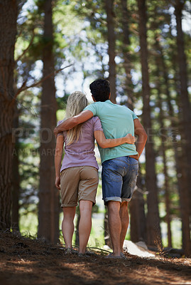Buy stock photo Couple, walking and hug in forest for love, embrace or support in trust, care or bonding in nature. Rear view or back of young man and woman in romance, affection or hiking together in outdoor woods