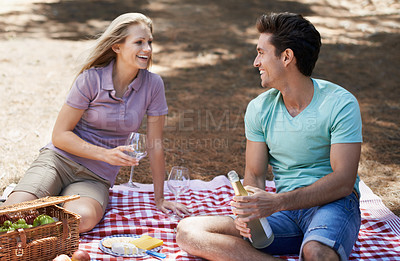 Buy stock photo Couple, picnic and wine glass in nature with love, celebration and summer date or romance for valentines day. Young people with food, fruits and bottle of champagne in woods or forest on anniversary