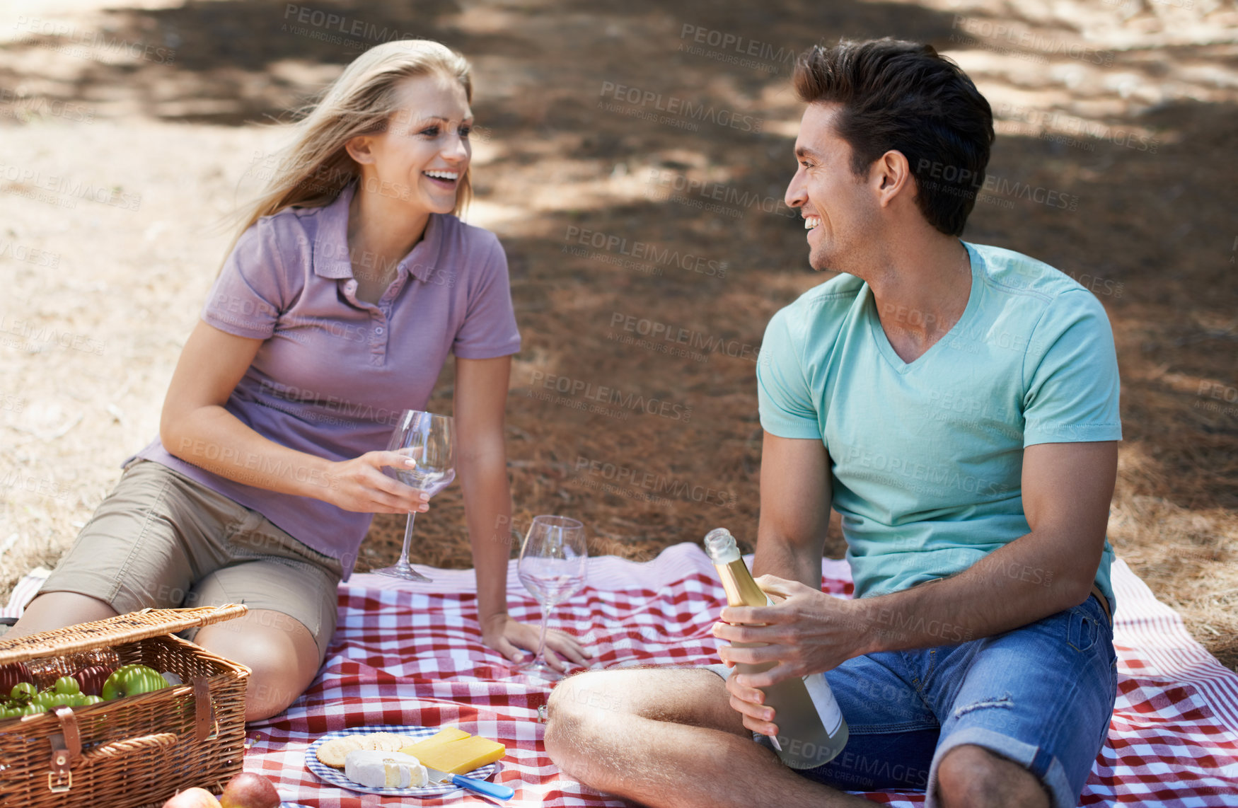 Buy stock photo Couple, picnic and wine glass in nature with love, celebration and summer date or romance for valentines day. Young people with food, fruits and bottle of champagne in woods or forest on anniversary