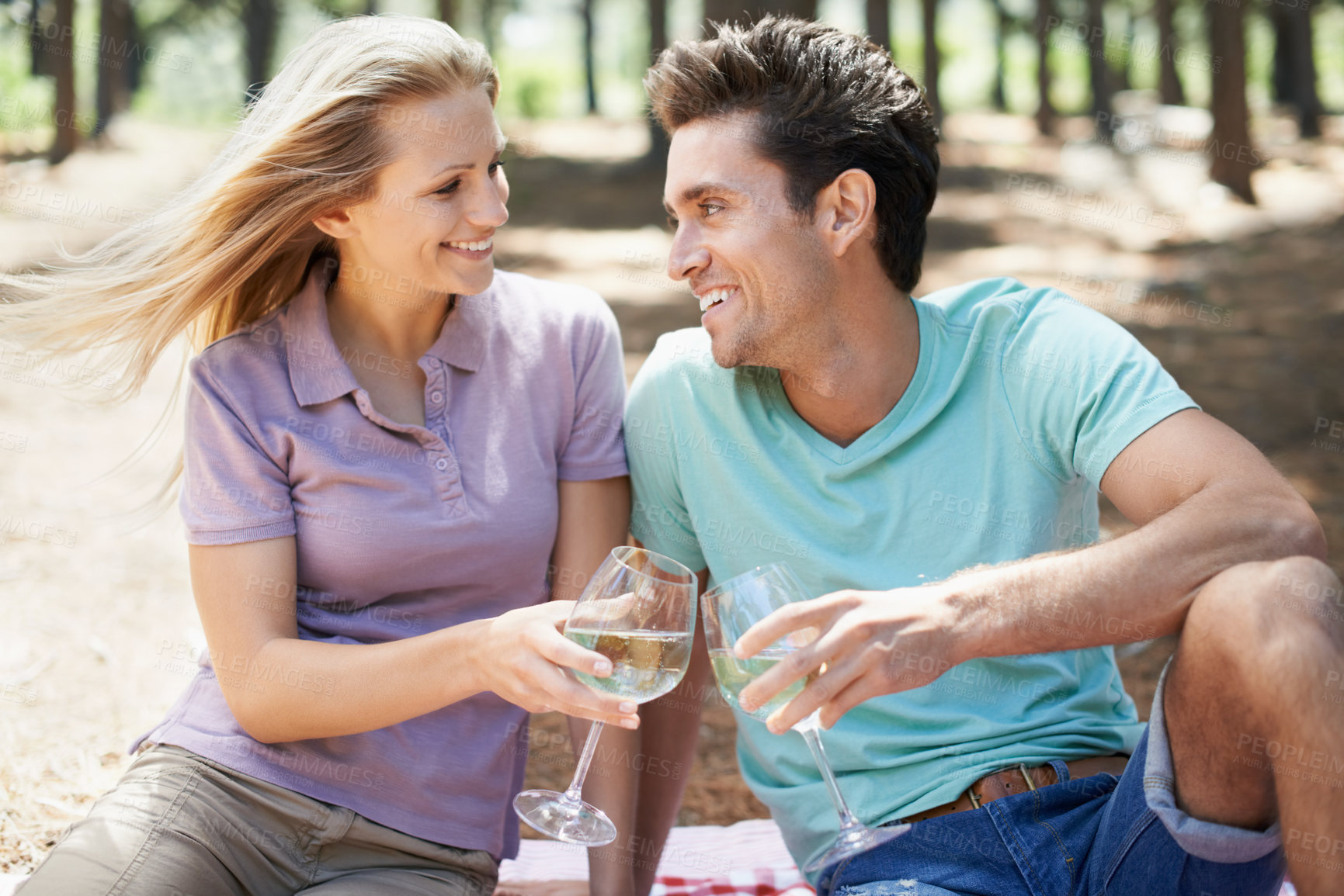 Buy stock photo Happy couple, wine glass and forest or park for cheers of love, holiday and valentines day picnic. Man and woman with champagne, drinks and toast on date and excited for anniversary in nature