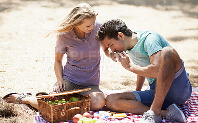 Buy stock photo Couple, relax and eating on picnic in nature for love, care or support on outdoor date on floor mat. Man and woman with fruit basket and enjoying healthy meal, snack or vitamins together in forest