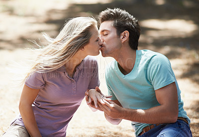 Buy stock photo Couple, kiss and engagement ring for love, support or commitment in nature, forest or outdoor getaway. Man and woman kissing on vacation, romance or affection for marriage, lovers or wedding proposal