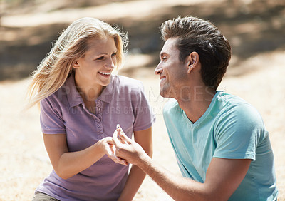 Buy stock photo Happy couple, engagement and ring in nature for love, support or commitment in forest or outdoor romance. Young man and woman or lovers smile in embrace or affection for marriage or wedding proposal