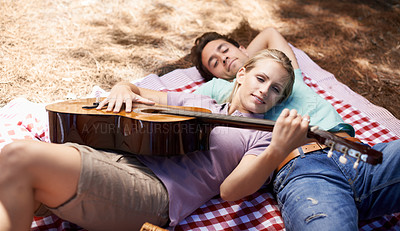Buy stock photo Couple, picnic and playing guitar for romance, music or love in outdoor bonding, fun or relaxing together in nature. Young man and woman smile with instrument for acoustic sound or songs outside
