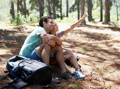 Buy stock photo Couple, hiking break and travel in nature for outdoor sightseeing, adventure and wellness journey in forest. Happy man and woman relax on ground and talking of trekking destination with backpack