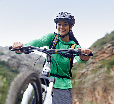 Buy stock photo An attractive young woman mountain biking in a scenic setting