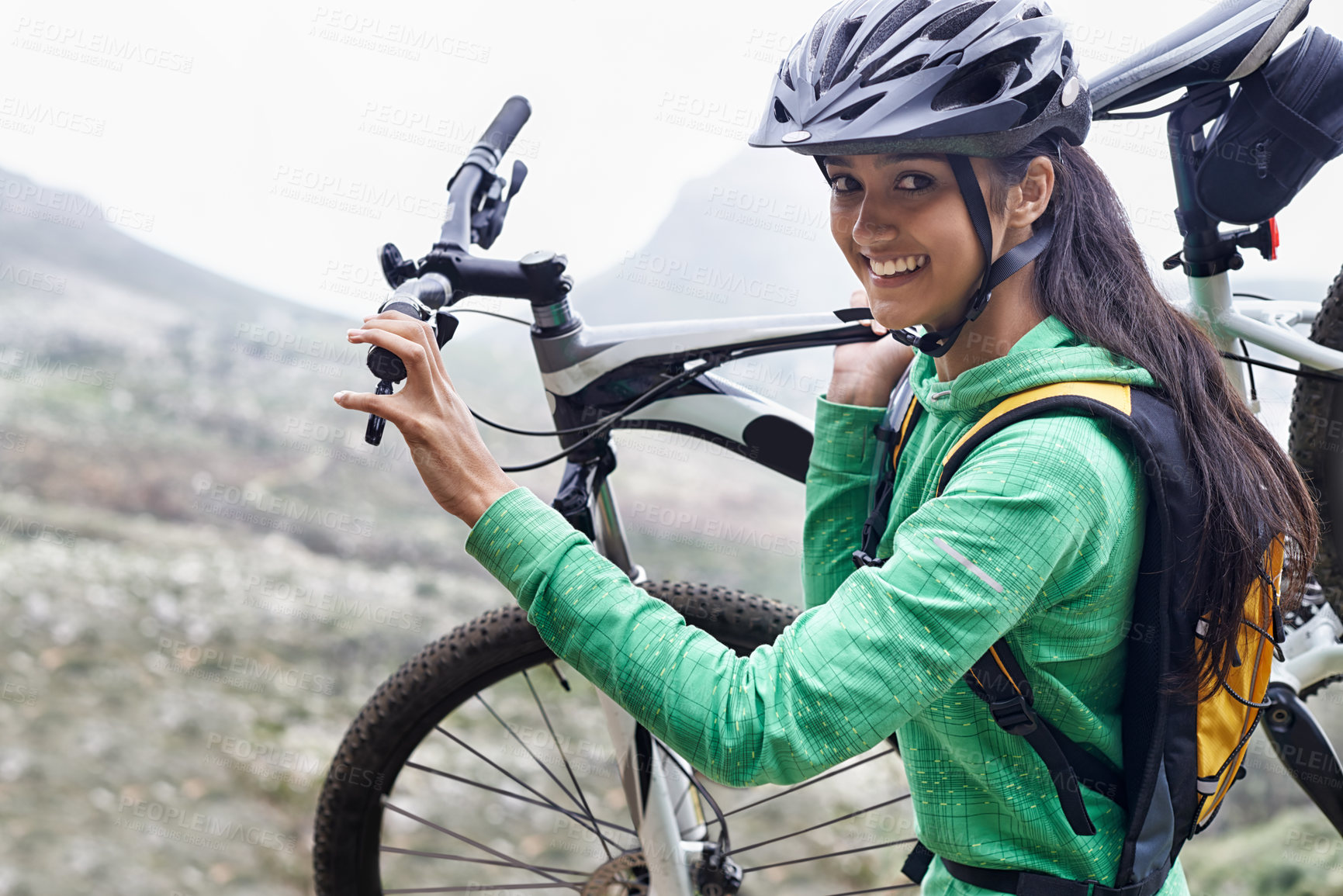 Buy stock photo A pretty young woman carrying her mountain bike
