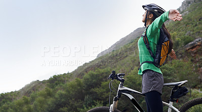 Buy stock photo A pretty young woman mountain biking in a scenic setting